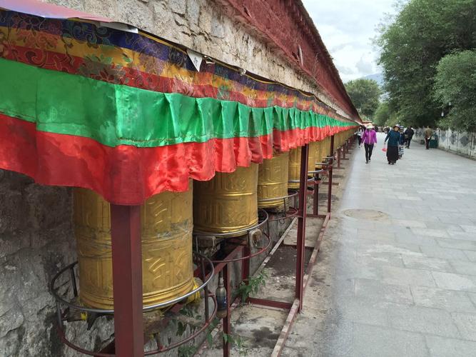 布达拉宫出口的转经筒,转动转经筒就等于诵经,有许多藏民转经经过