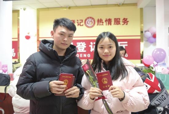 2月14日,长沙雨花区民政局婚姻登记处,一对新人正展示刚领到的结婚证